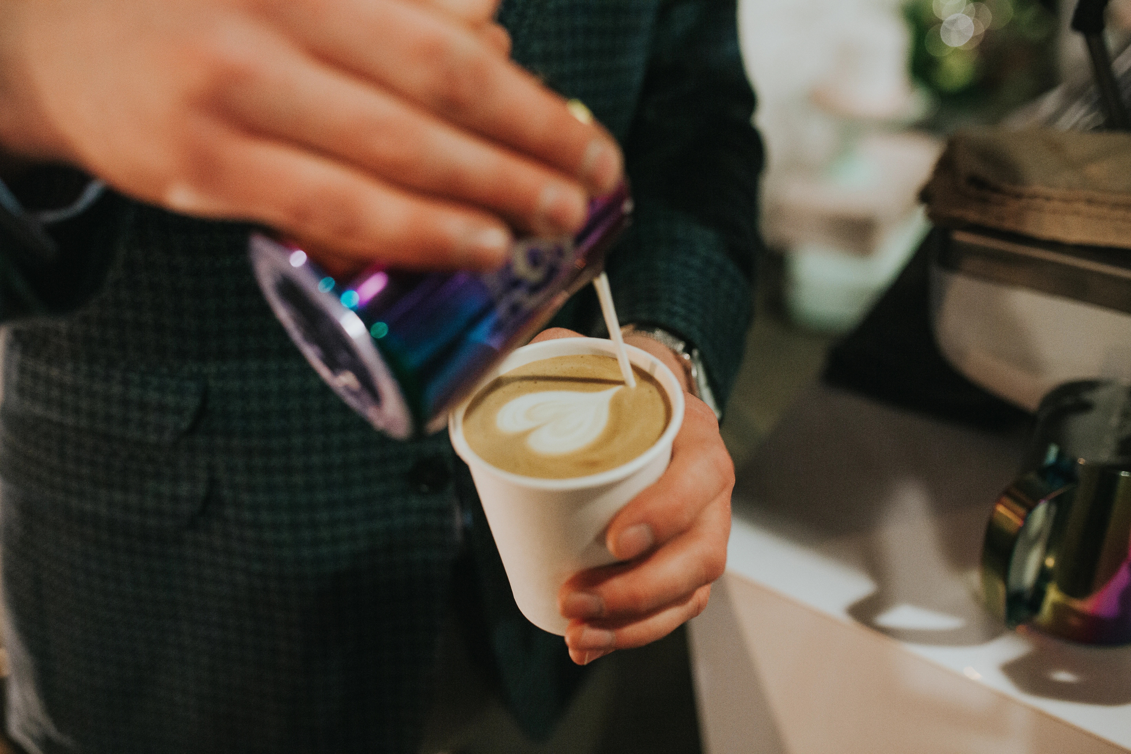 Picture of a person pouring milk into coffee cup